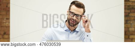 Mirthful Man Looking At The Screen With Contented Smile