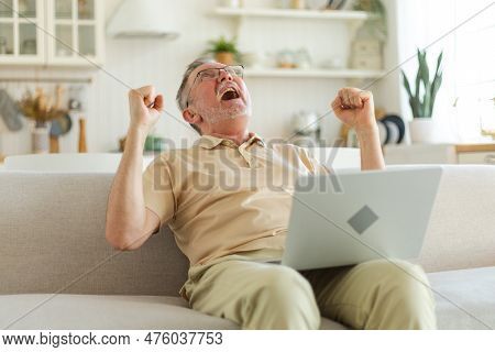 Excited Middle Aged Senior Man Euphoric Winner. Older Mature Grandfather Looking At Laptop Reading G