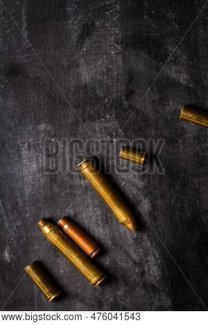 Empty Bullet Cartridges Lying On The Black Background.