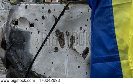 Bullet And Shrapnel Holes In The Civilian Transport Hull And The Ukrainian Flag On It After The Bigg