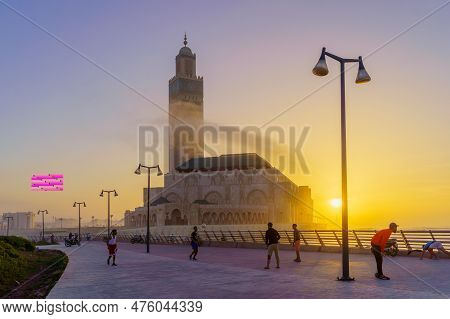 Casablanca, Morocco - March 29, 2023: Sunset Scene Of The Hassan Ii Mosque, With Locals Playing Foot