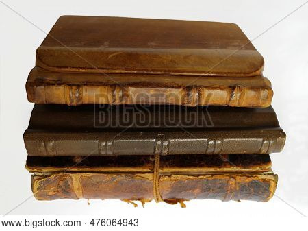 Collection Of Three Old Books On A White Background. The Cover Of These Books Is Made Of Leather Or 