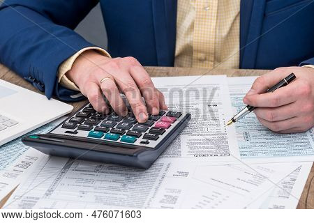 Businessman Works With W-4 Tax Form And Calculator