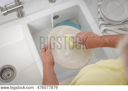Man Washing Plate Above Sink, Top View