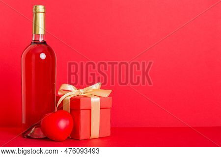 Bottle Of Wine On Colored Background For Valentine Day With Gift Box. Heart Shaped With Presrnt Box 