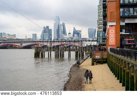 London - April 21, 2023: Enjoy A Leisurely Walk Along The Sandy Thames River Beach, Taking In Views 