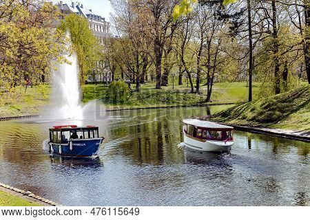 Latvia, Riga, May, 2023: Pleasure Boats With Tourists Cruise Along The Riga River Canal Near Bastion