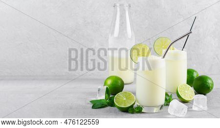 Brazilian Lemonade, Refreshing Creamy Lemonade Or Limeade With Lime Slices And Mint On Grey Backgrou