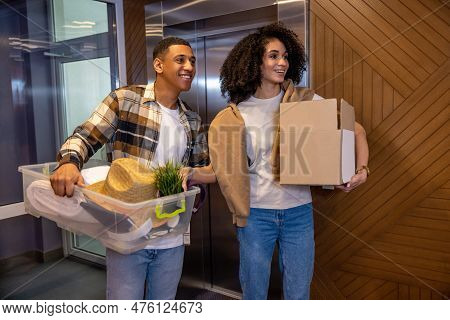 Young Couple With The Clothes In Hands In The Hotel