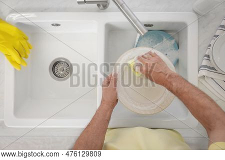 Man Washing Plate Above Sink, Top View