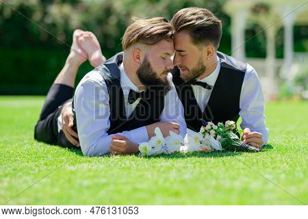 Gay Couple Laying On Grass On Wedding Day. Romantic Men Same Sex Marriage. Gay Couple Wedding. Homos