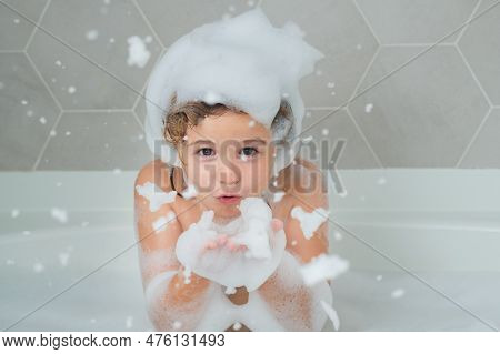 Child Blow Shampoo Foam And Bubbles On Hair Taking Bath. Portrait Of Smiling Kid, Hair Care And Hygi