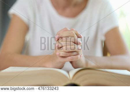 Close-up Of Woman Sitting At Table And Putting Hands In Lock On Book. Female Reader Or Lawyer. Educa