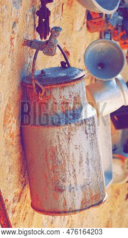 Worn Antiquary Stuff Hanging On The Wall. Obsolete Things. Rusty Reservoir. Toned Photo