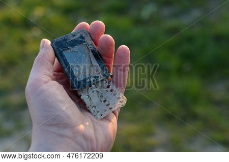 Damaged Old Cell Phone In Hand - E-waste Recycling Issue/