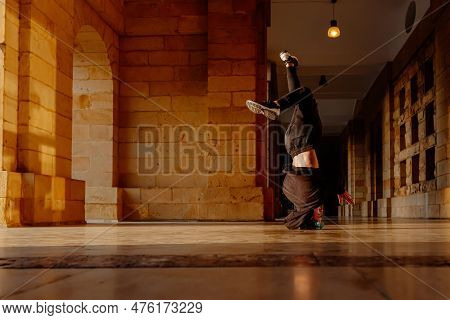 Teenager Boy Dancing Breakdance On A Tiled Floor In The Street. Youth Culture And Hip-hop Culture