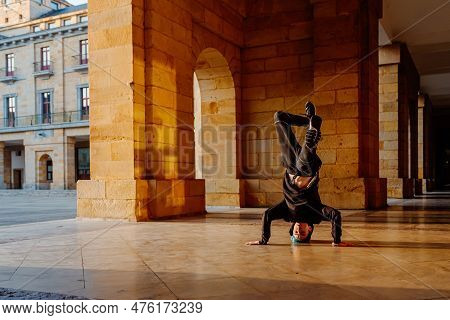 Teenager Boy Dancing Breakdance On A Tiled Floor In The Street. Youth Culture And Hip-hop Culture