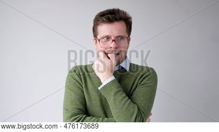 A European Young Man Is Nervous And Biting His Nails.