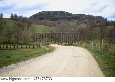 Unpaved Sinuous Country Road On A Spring Afternoon. Rural Scenery In Covasna, Romania