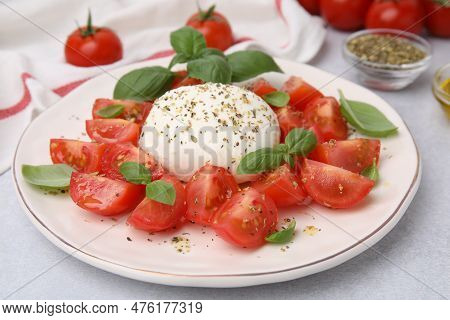 Tasty Salad Caprese With Mozarella, Tomatoes And Basil On Light Table, Closeup