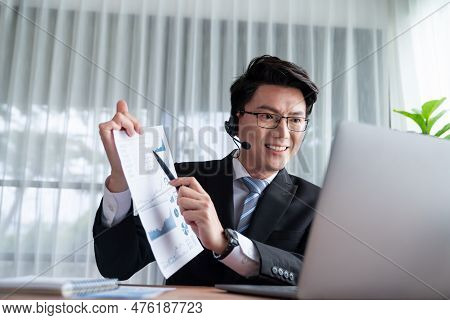 Confident Asian Telesales Businessman Work In Modern Office Wearing Headphone, Presenting Bi Dashboa