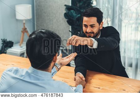 Closeup Real Estate Broker Or Landlord Shake Hand With Buyer And Give A Key. Client Agree On House L