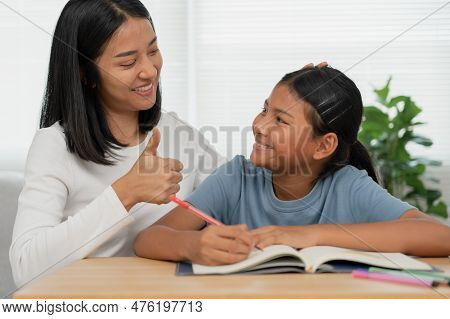 Mother Teaching Lesson For Daughter. Asian Young Little Girl Learn At Home. Do Homework With Kind Mo