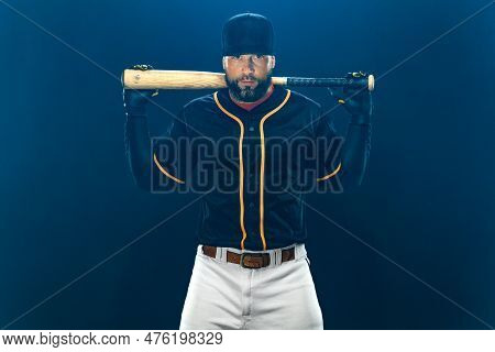Baseball Player With Bat On Dark Background. Ballplayer Portrait.