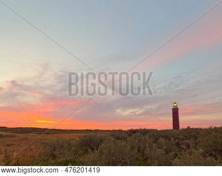 Red Brick Structure Of Vuurtoren Westhoofd Lighthouse In Ouddorp, Netherlands. Wide Shot With Dunes 
