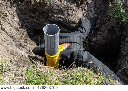Overflow and infiltration well connected to drainage pipes, dug in a ditch.