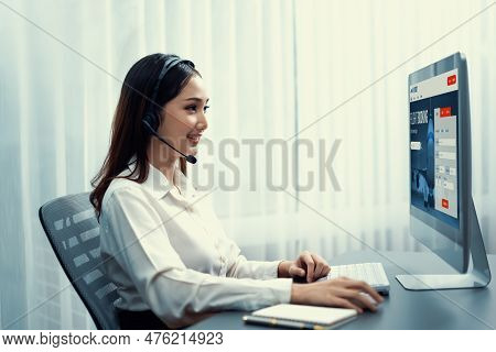 Asian Call Center With Headset And Microphone Working On Her Laptop. Female Operator Provide Excepti