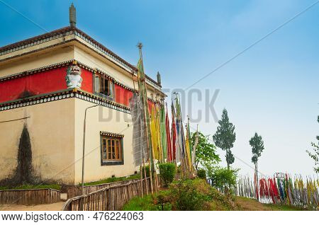 Buddist Religious Prayer Flags And Trees Standing Tall Outside Monastery In Sikkim, India. Blue Sky 