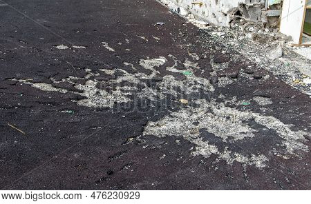 War In Ukraine. Funnel From The Explosion In The Asphalt. The Trace Left By The Explosion Of An Arti