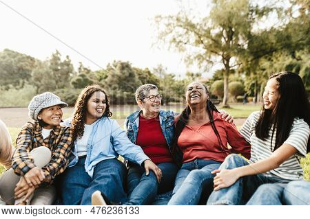 Happy Multi Generational Group Of Women With Different Ethnicities Having Fun Sitting On Grass In A 