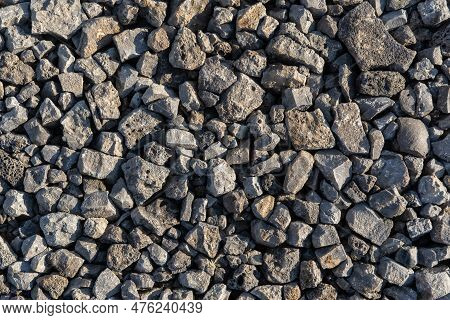 Gray Texture From Pieces Of Lstones In A Pile On The Street. Dark Gray Pattern Of Pebbles. Abstract 