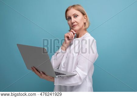 Portrait Of Successful Mature Business Woman With Blond Hair Surfing The Internet Using Laptop