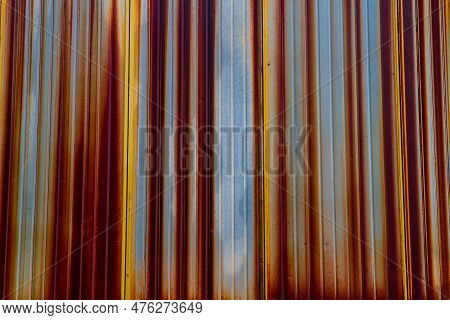 Close-up. Old Rusty Corrugated Sheet. Coloured Striped Background.