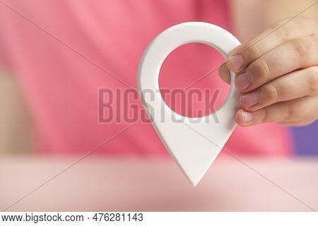A Hand Holds A Location Sign On A Purple Background. Laying A Route, Finding The Location Of A Point