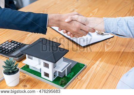 Finalizing House Loan Agreement With Handshake, Buyer And Real Estate Agent Celebrate Accomplishment