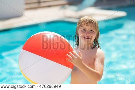 Happy Child Having Fun On Summer Vacation. Kid Playing With Ball In The Swimming Pool. Kid Hold Rubb
