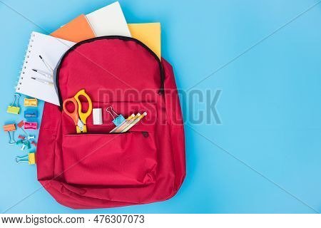 Top View Flat Lay Of Red School Bag Backpack And Accessories Tools For Children Education On Blue Ba