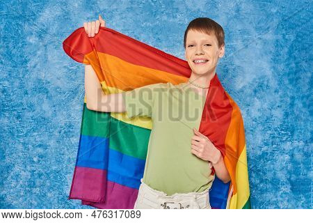 Cheerful Gay Man In Casual Clothes Smiling And Holding Lgbt Flag And Looking At Camera During Pride 