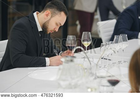Young Man Sommelier Tasting White Wine During Study In Wine School. Alcoholic Beverages Degustation.