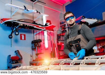 Male Engineer Or Technician Working On Drone Details In Lab. Aircraft Capable Of Gps Surveillance. C