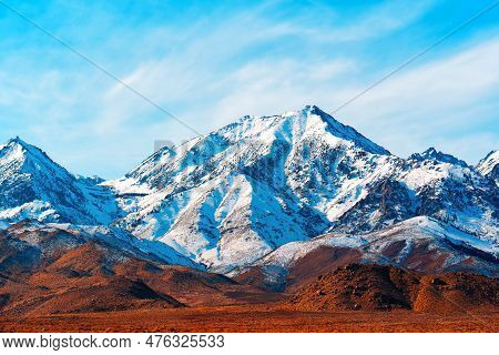 Snowy Mount Whitney Peak Towering Over The Sierra Nevada Mountain Range Against A Blue Sky.