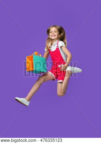 Glad Teen Girl Jumping After Shopping In Studio. Teen Girl Jumping After Shopping