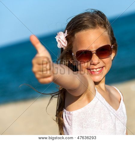 Słodkie dziewczyny pokazano kciuki na plaży.