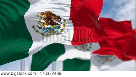 Three Mexican National Flags Waving In The Wind. Vertical Tricolor Of Green, White, And Red With Nat