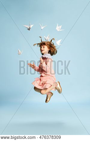 Full-length Portrait Of Playful, Lovely Little Girl In Pink Dress Posing, Playing With Paper Birds A
