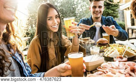 Happy Multi-ethnic Friends Dining Together At Brewery Pub Restaurant